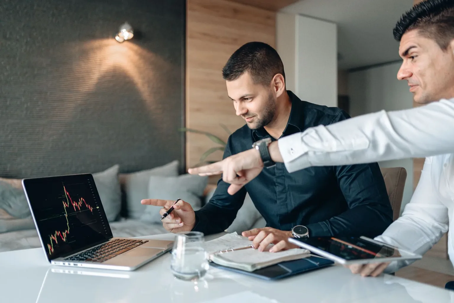 Traders reviewing market charts and journal notes while analyzing trading performance